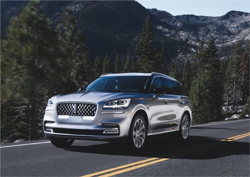 A 2023 Lincoln Aviator® Grand Touring SUV being driven on a winding road to demonstrate the capabilities of all-wheel drive | Miller Lincoln in Saint Cloud MN