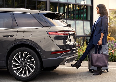 A woman with her hands full uses her foot to activate the hands-free liftgate. | Miller Lincoln in Saint Cloud MN