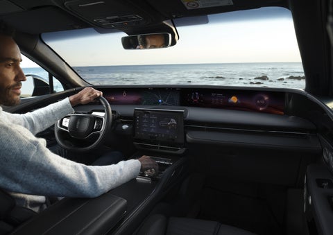 A driver of a parked 2026 Lincoln Nautilus® SUV takes a relaxing moment at a seaside overlook while inside his Nautilus. | Miller Lincoln in Saint Cloud MN