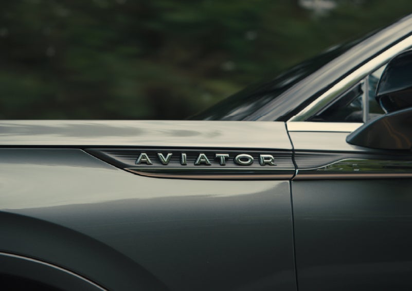 The driver’s side door and fender badging of a gray 2027 Lincoln Aviator® SUV are showcased. | Miller Lincoln in Saint Cloud MN