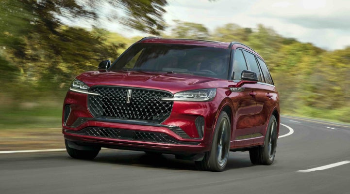A 2027 Lincoln Aviator® SUV is being driven on a country road | Miller Lincoln in Saint Cloud MN